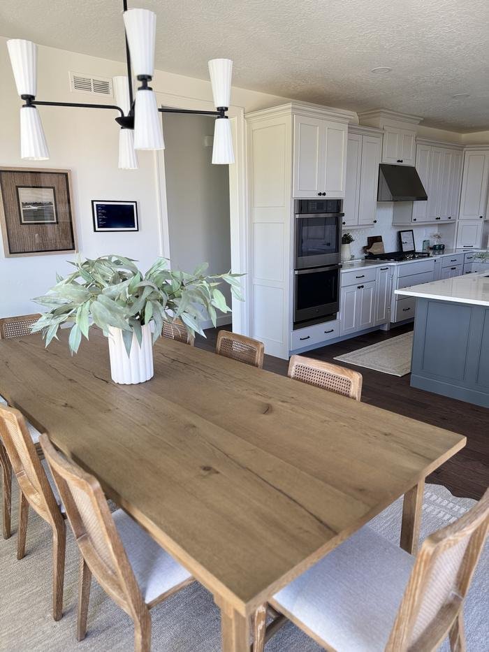 Oak dining table with cane chairs, kitchen behind