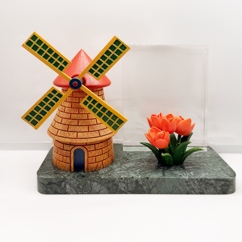 Close view of a painted windmill and colorful resin flowers