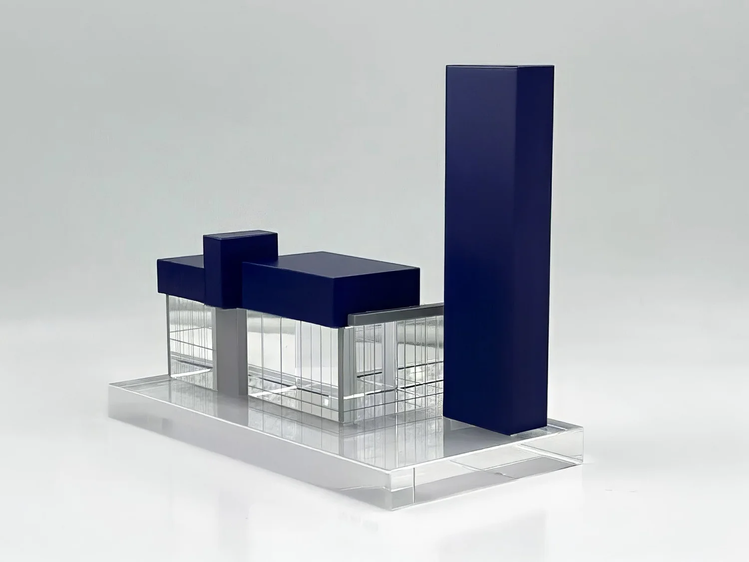 Architectural deal toy built from clear panels and deep blue vertical forms