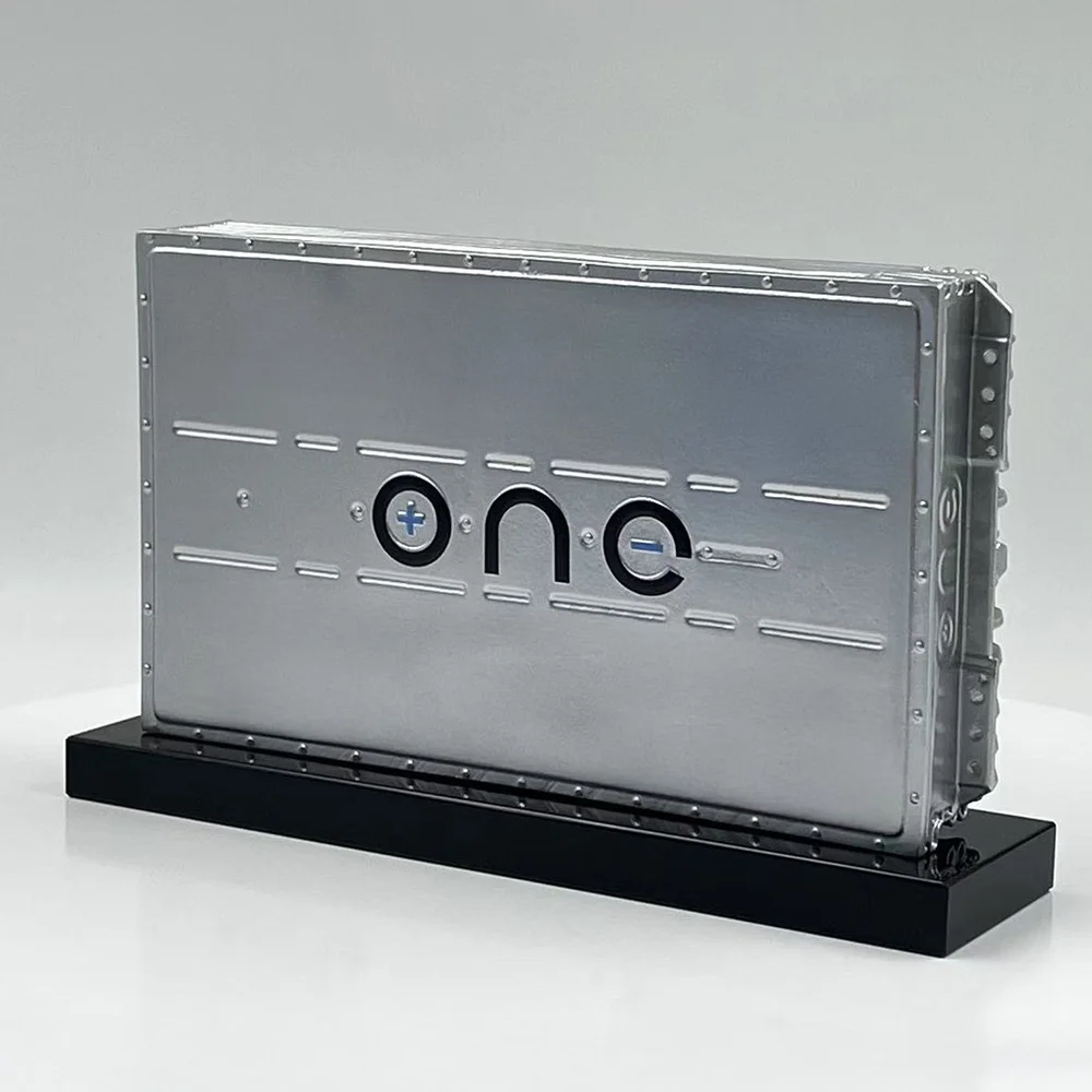 Metal battery replica with detailed panels on a black base