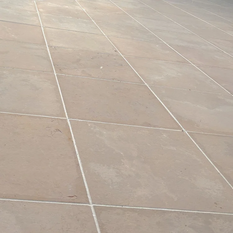 Light sealant lines across warm-colored stone paving.