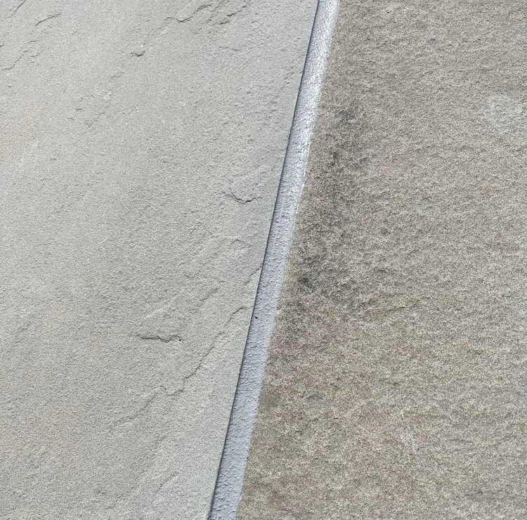 Textured gray sealant between two stone surfaces.