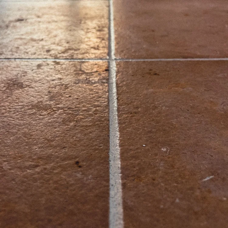 Textured light sealant crossing between warm-colored stone surfaces.