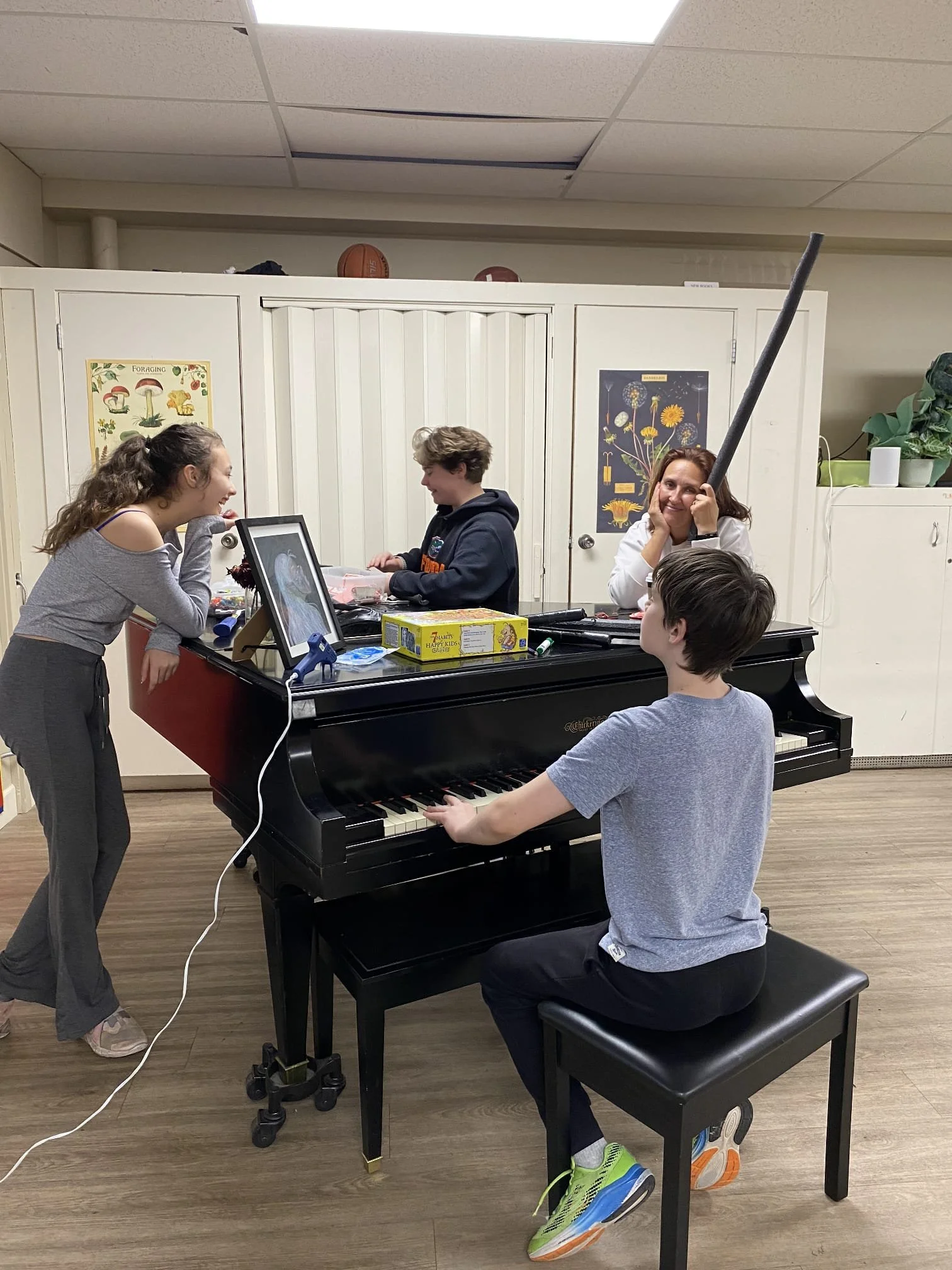 Students playing a Piano and laughing with each other