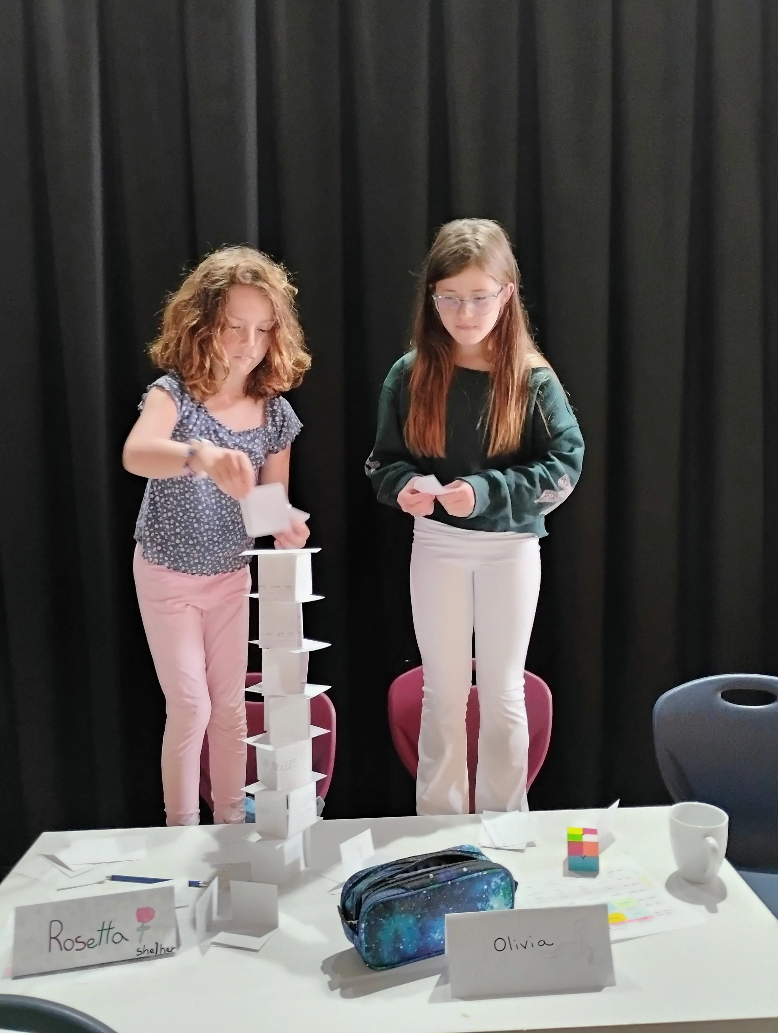 Student smiling while making paper sculptures