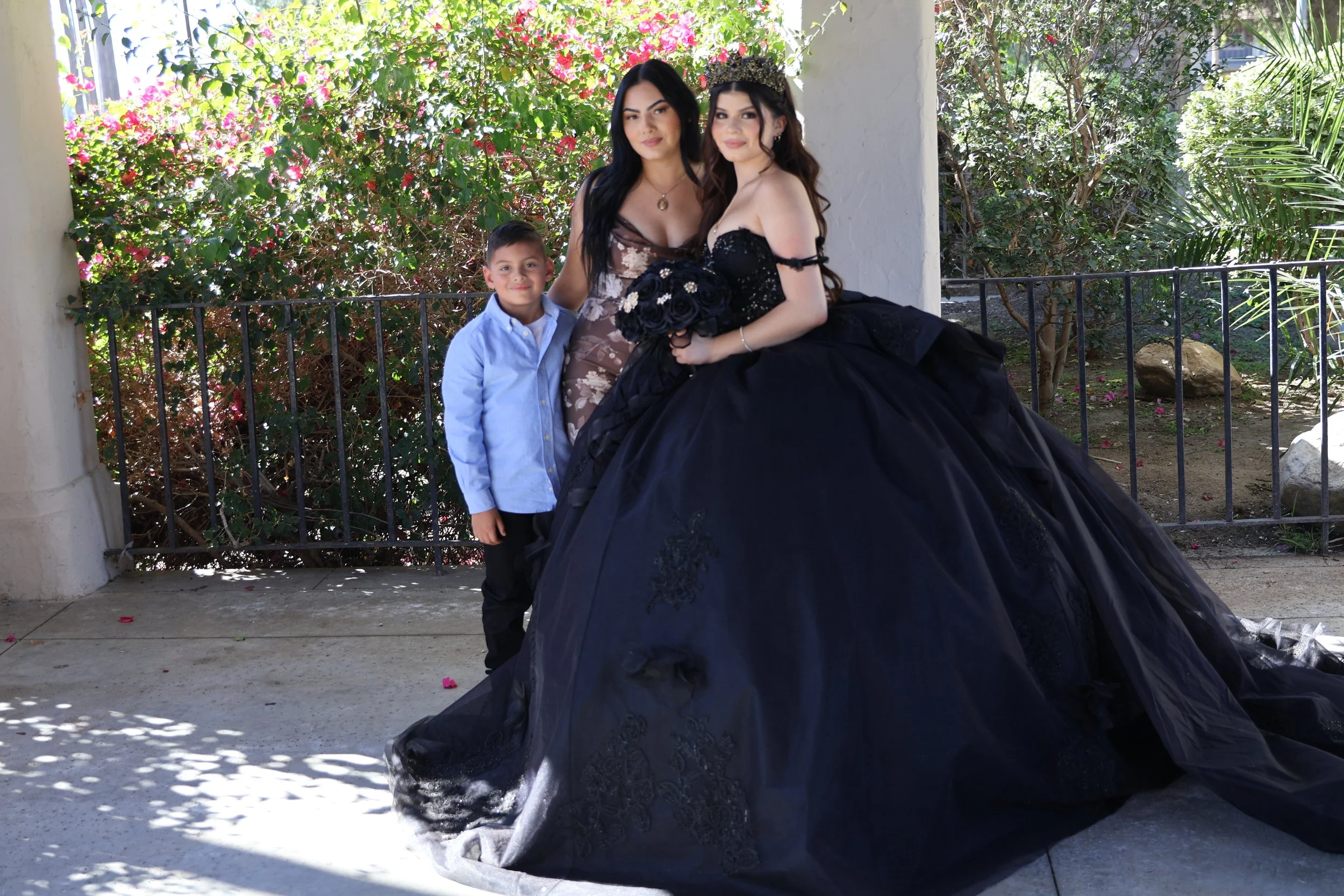 Quinceañera portrait in a dark gown outdoors