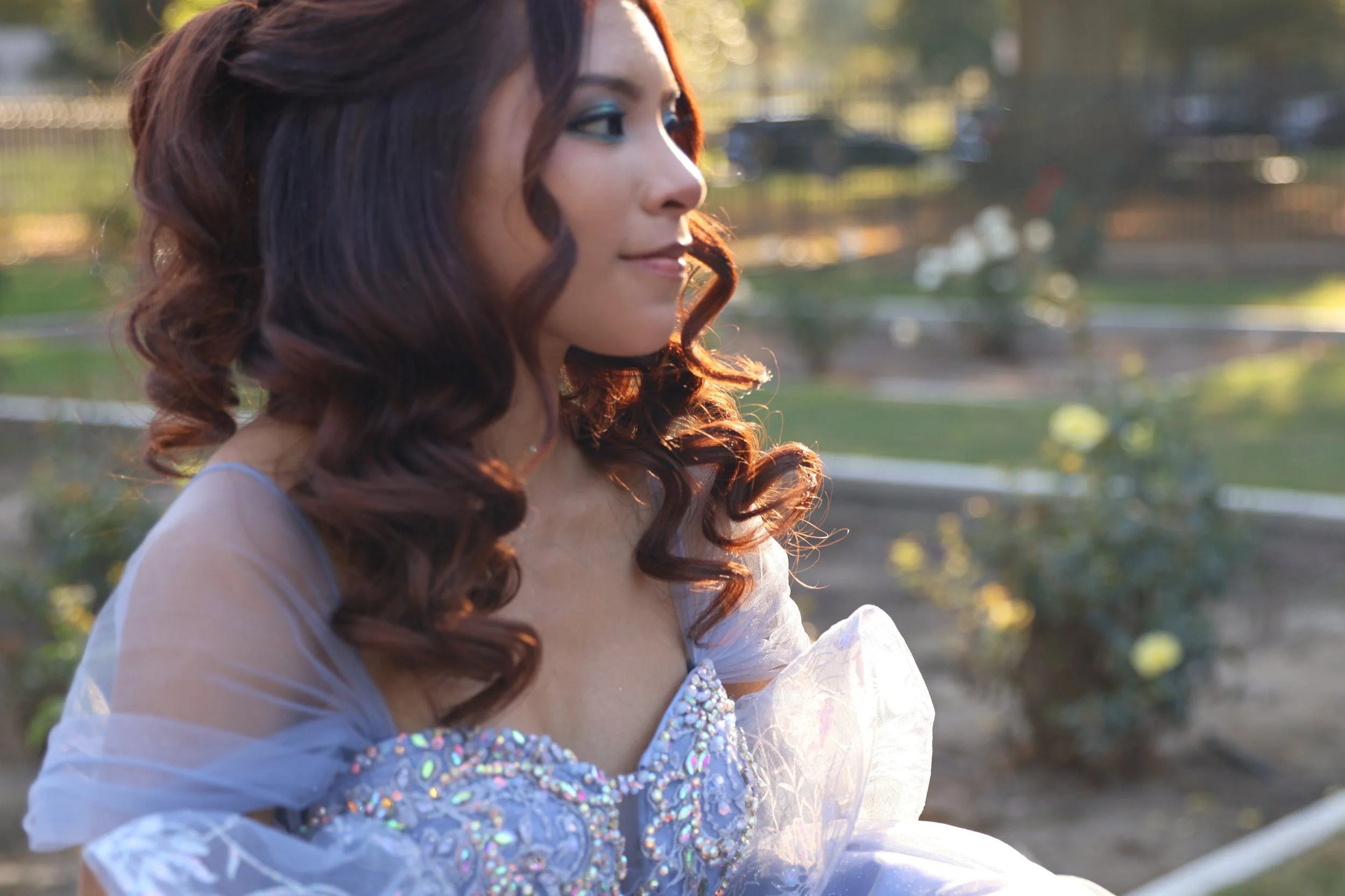 Quinceañera in a blue gown outdoors