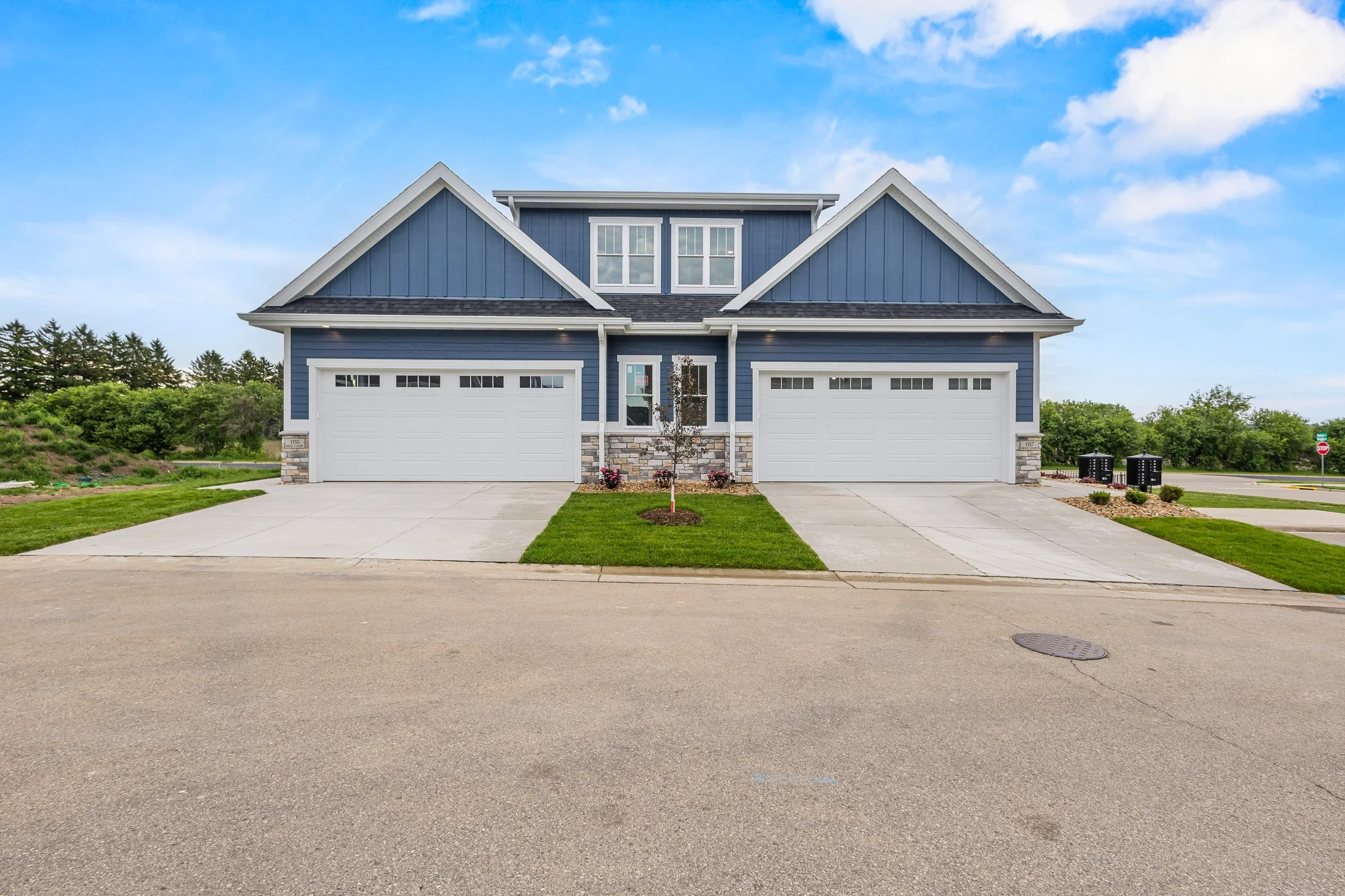 Front-facing photograph of 1155 and 1157 Irene Court, showing the matching front entries and two attached garages