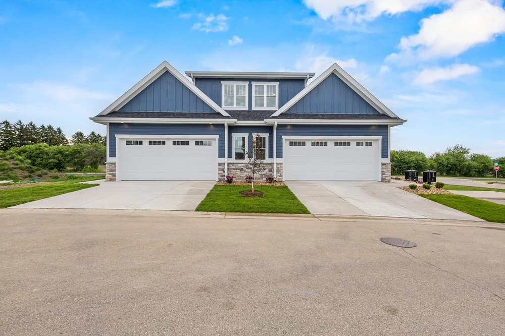 Front-facing photograph of 1155 and 1157 Irene Court, showing the matching front entries and two attached garages