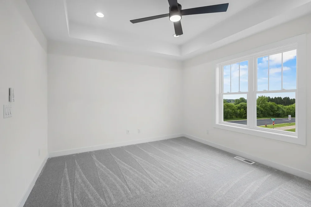 Irene Court — Primary bedroom with tray ceiling and broad windows