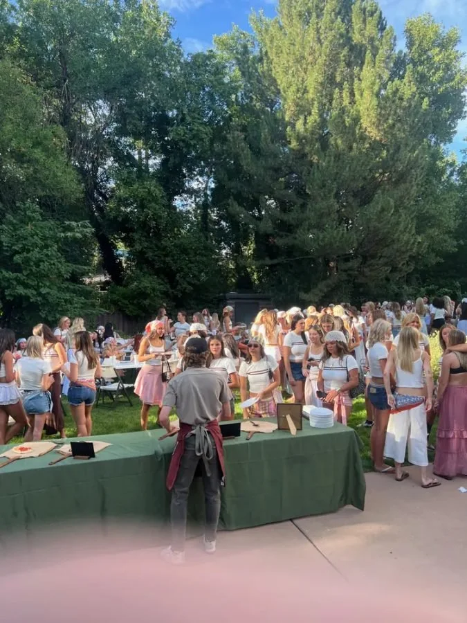 Guests gathering around the pizza table at a graduation party