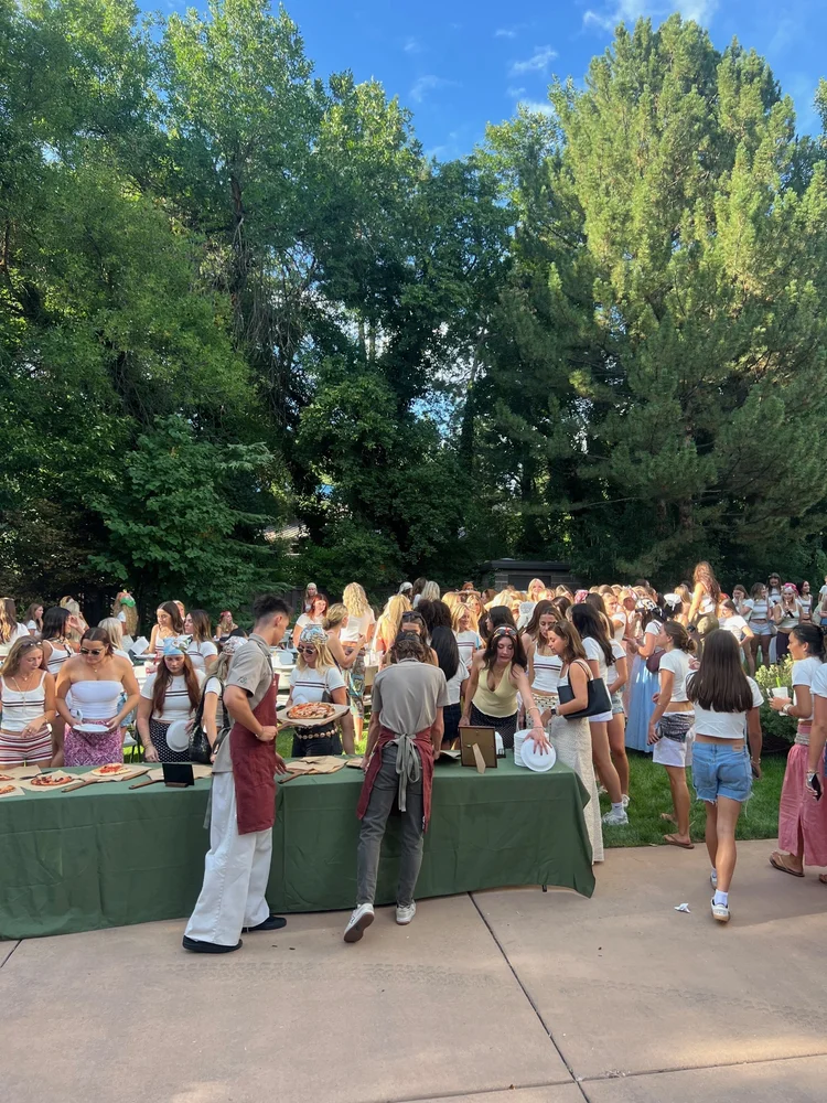 Backyard party crowd at the pizza station