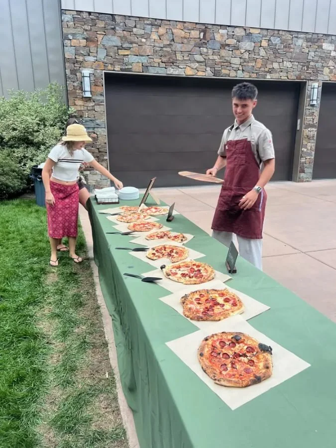 Backyard table lined with pizzas