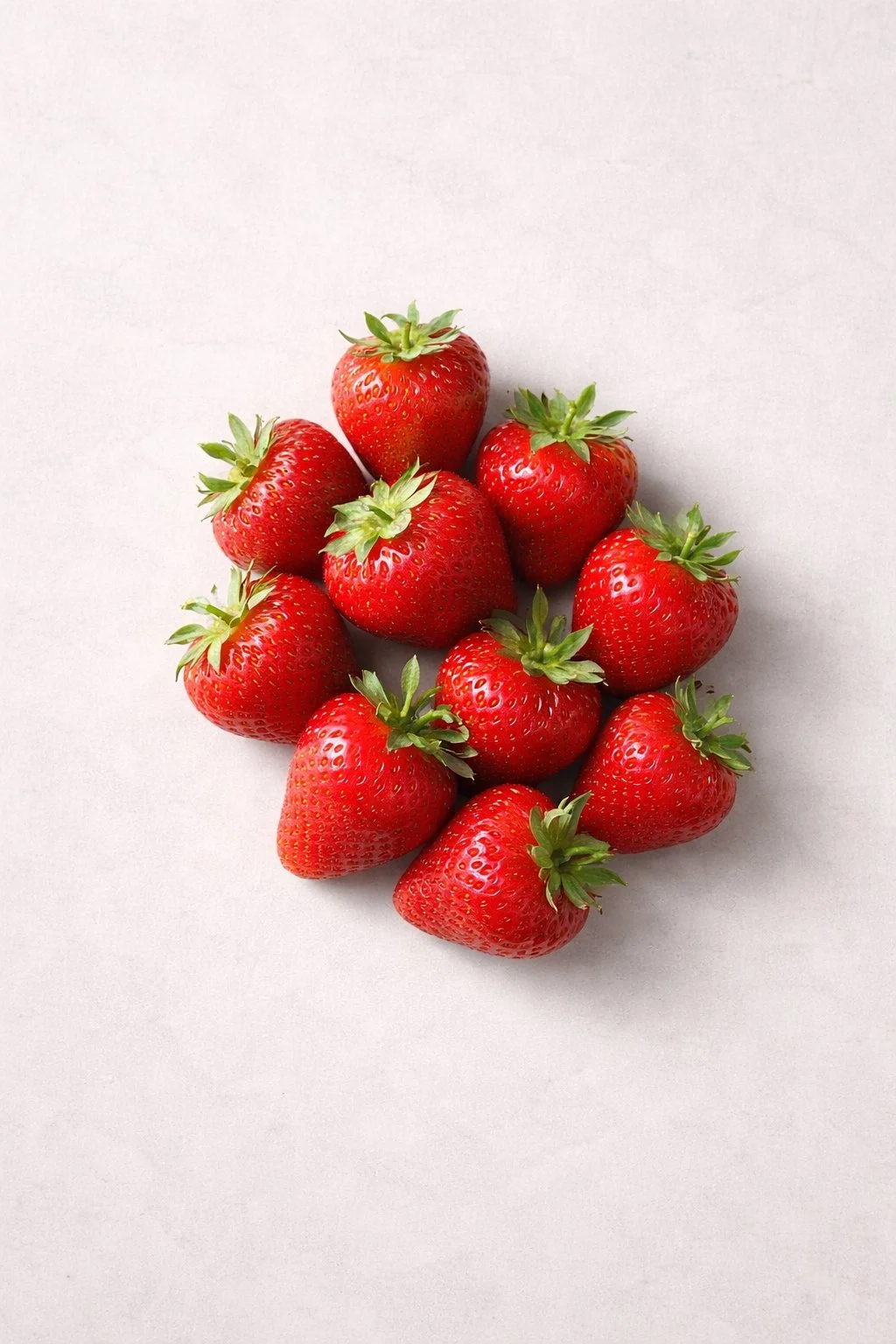 A cluster of fresh red strawberries on a white background