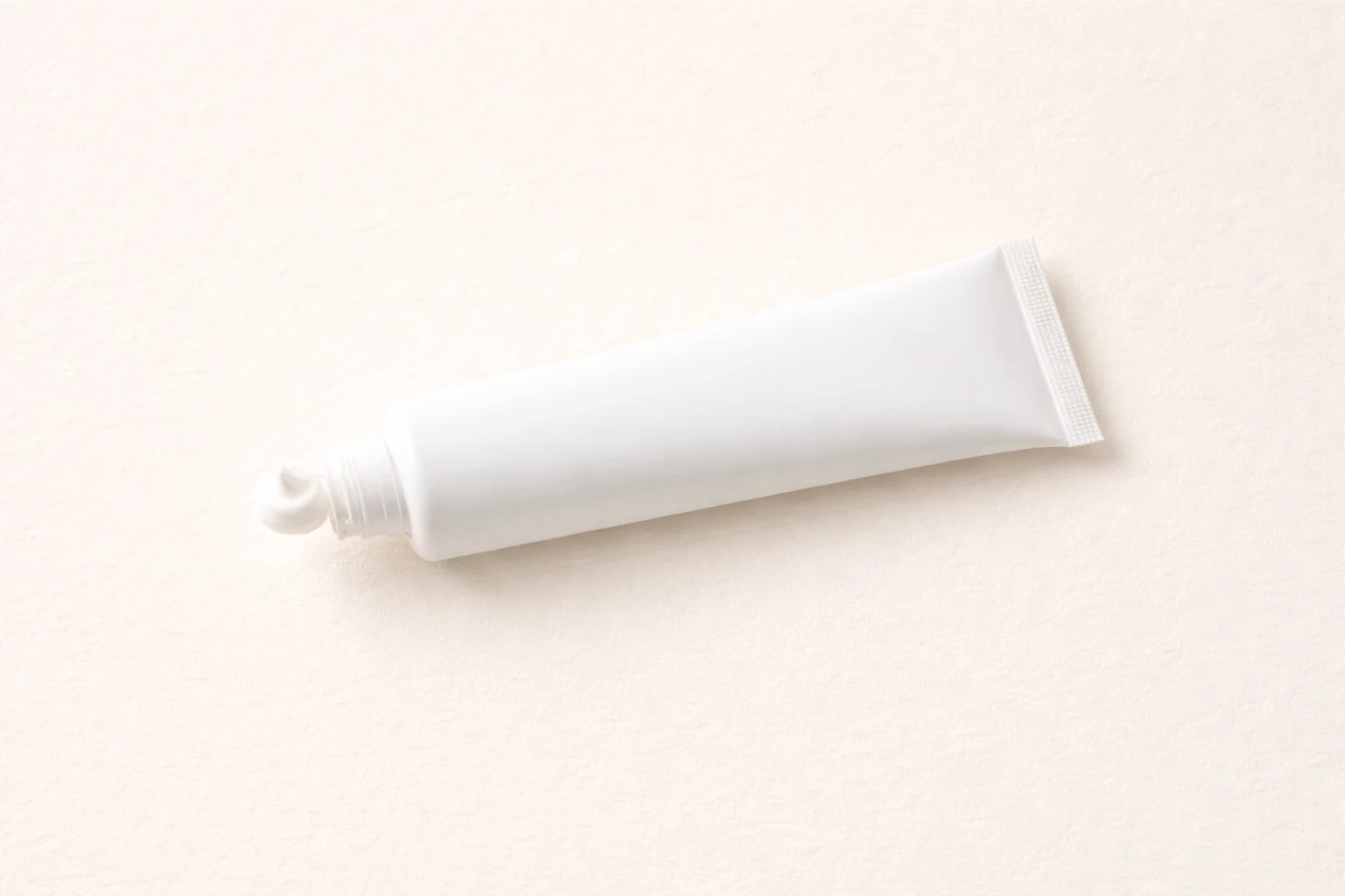 A white toothpaste tube on a light background