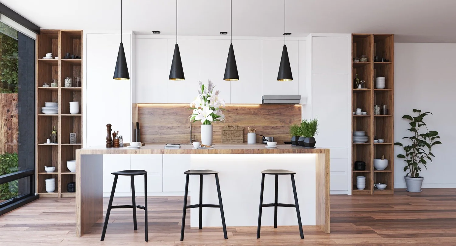 Modern kitchen with white cabinetry, a wood island, and black pendant lights.