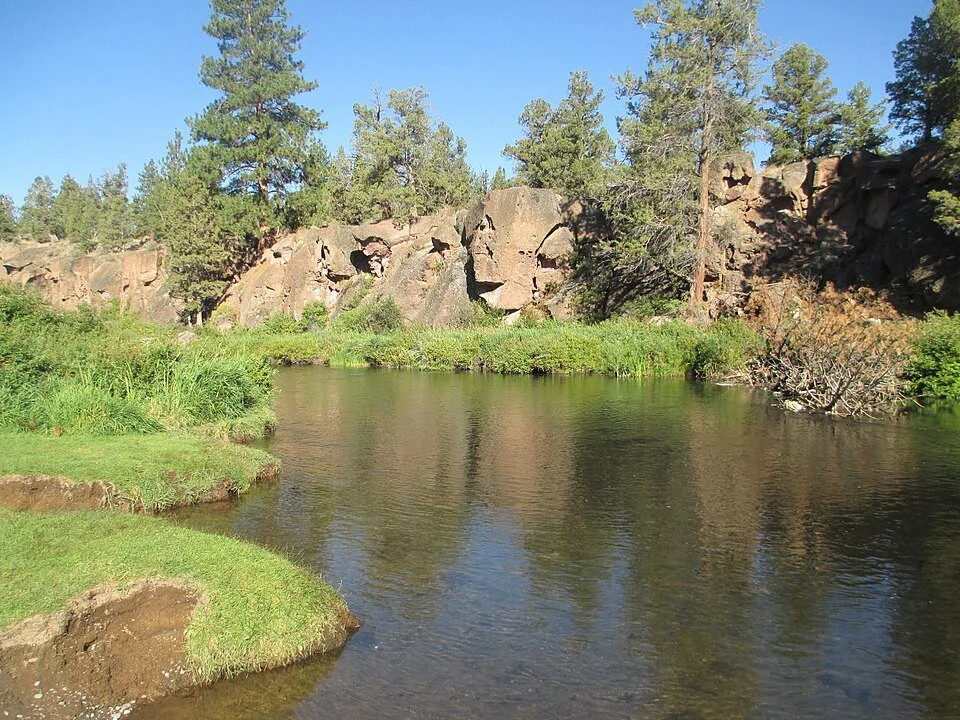 The Deschutes River below rocky banks and pine trees at Tumalo State Park.
