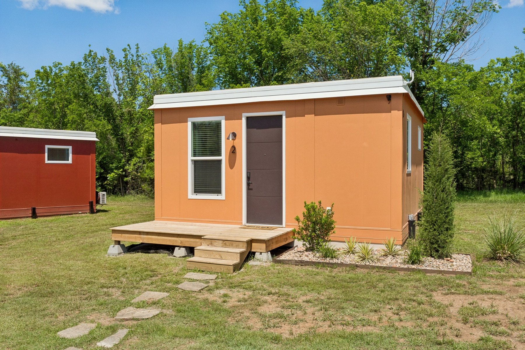 Orange Pasadera casita exterior with a front door and wooden entry steps