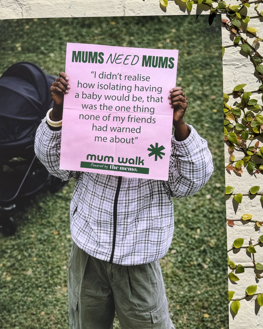 Mum holding a poster sharing her experience of loneliness in motherhood.