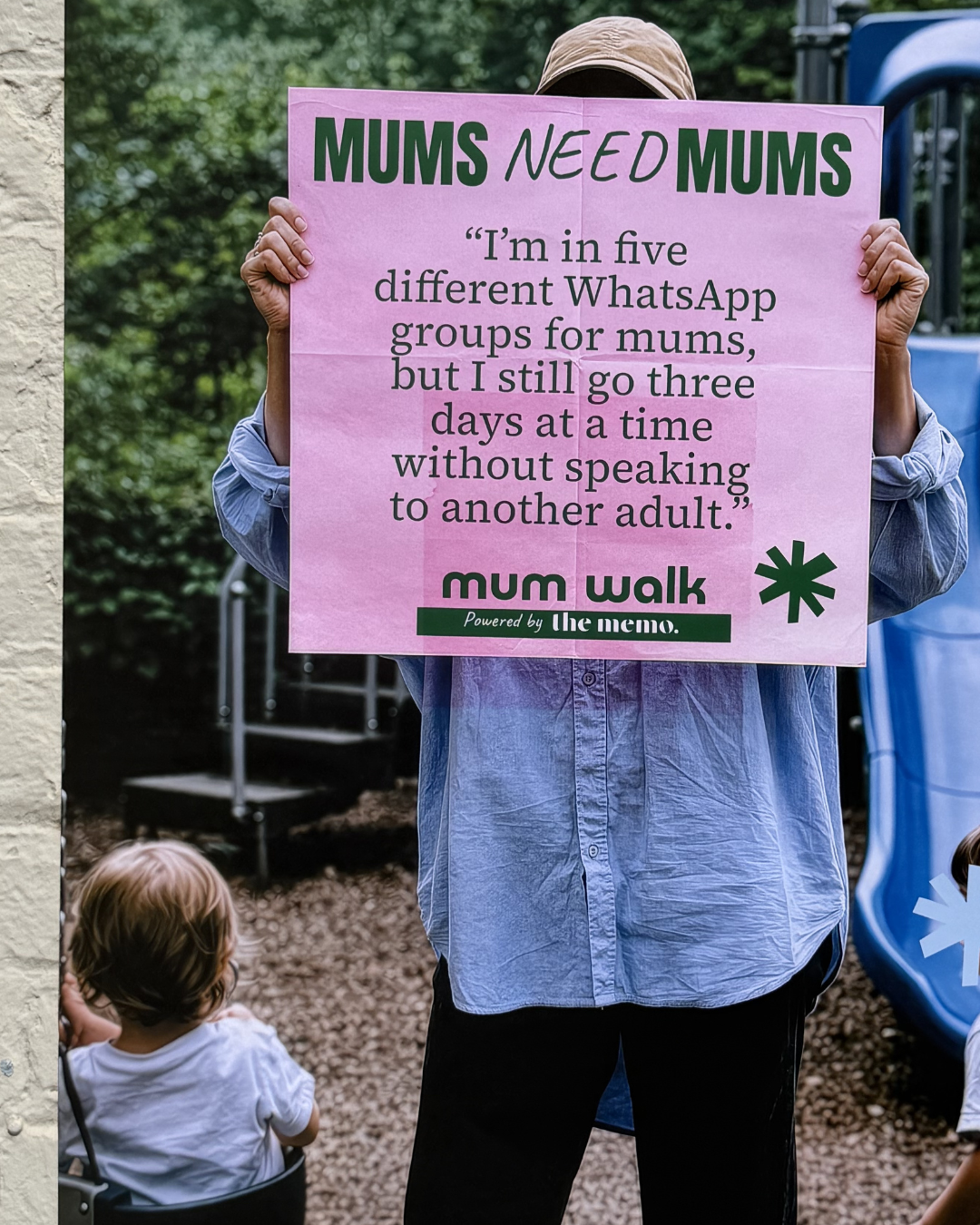 Mum holding a poster sharing her experience of loneliness in motherhood.