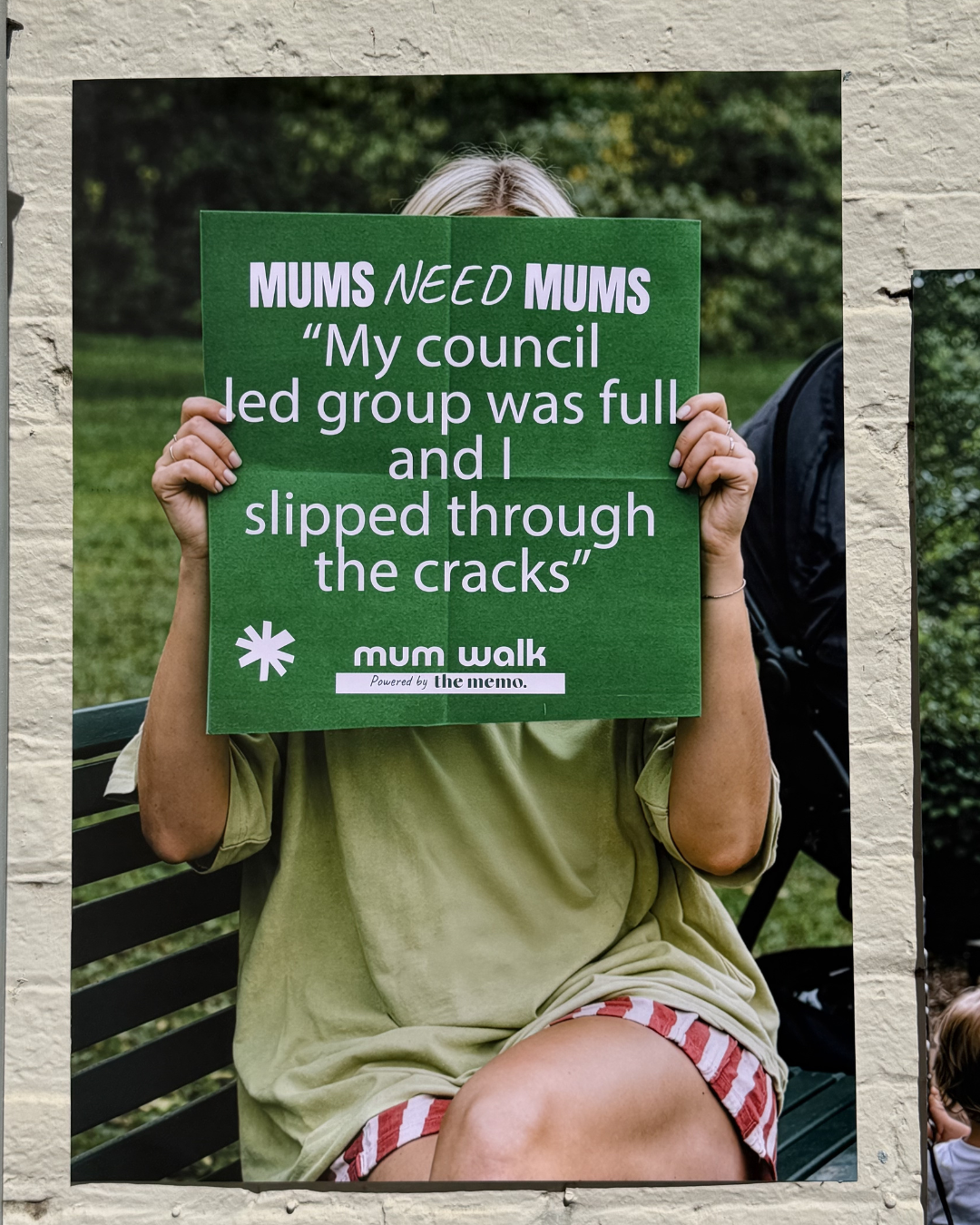 Mum holding a poster sharing her experience of loneliness in motherhood.