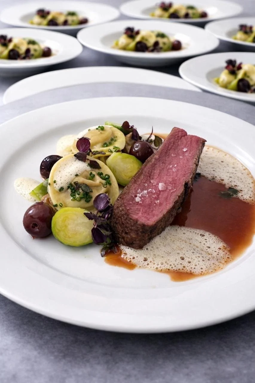 Rosa gebratenes Fleisch mit Ravioli, Kohlsprossen und Kirschen