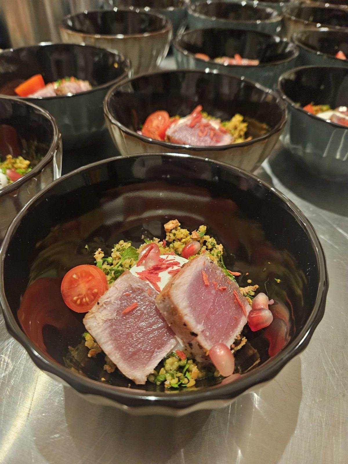Gebratener Thunfisch auf Couscous mit Granatapfel in schwarzen Schalen