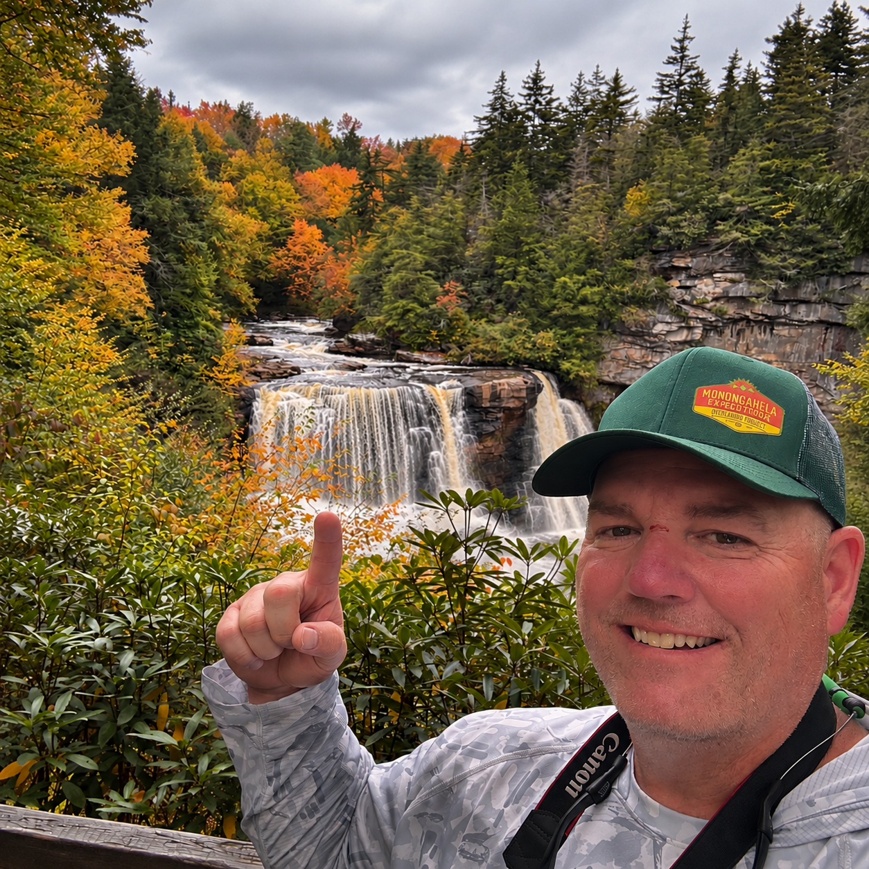Blackwater Falls pouring over dark rock ledges surrounded by orange and gold fall foliage at Blackwater Falls State Park, West Virginia