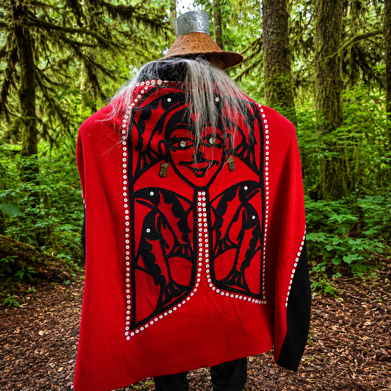 Alaska Native guide in traditional Tlingit regalia leading a forest trail walk in Klawock, Alaska