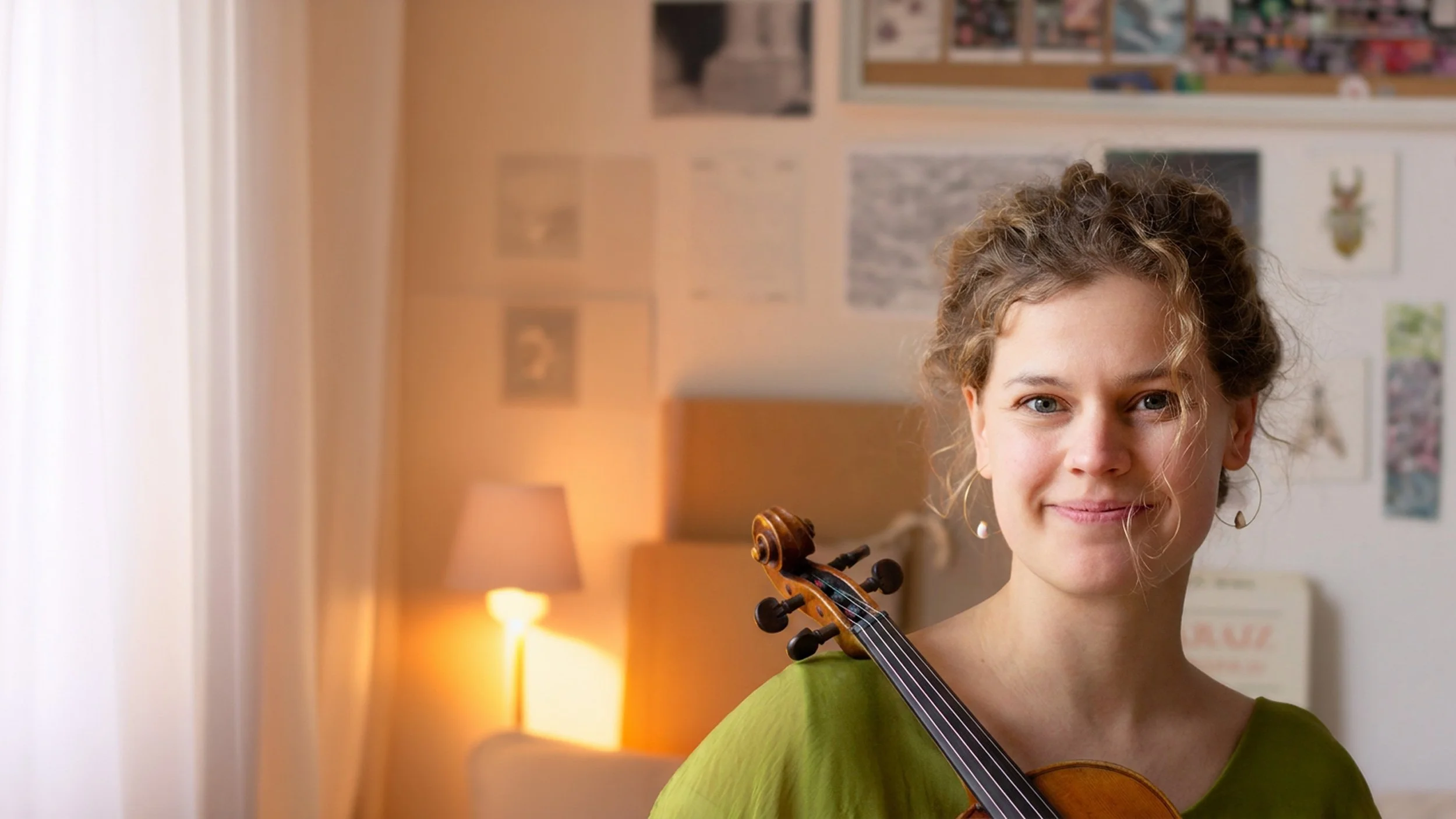 Léna Ruisz, violinist and founder of her adult violin studio, holding her violin in her Basel studio.