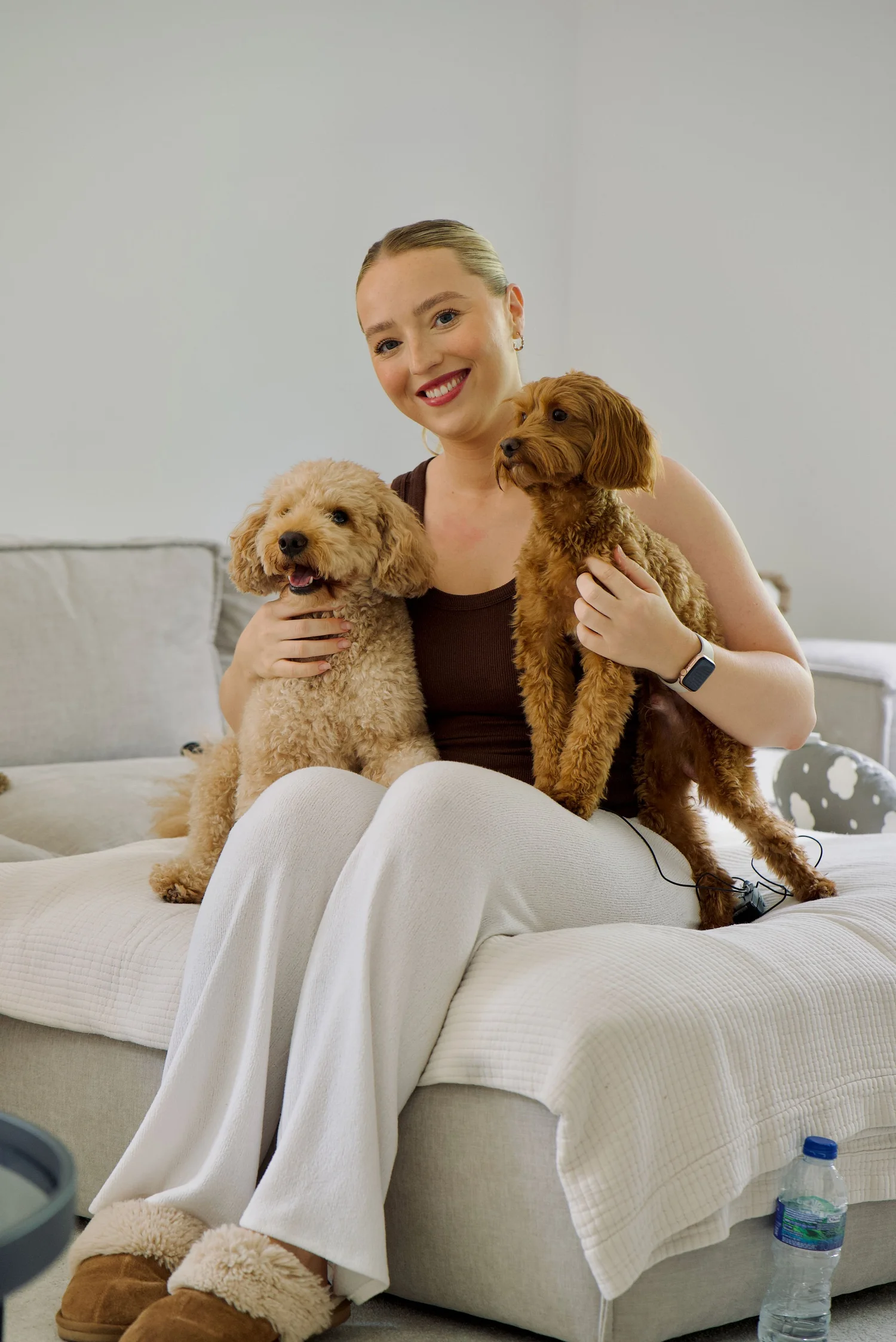 Owner at home with two Cockapoo puppies