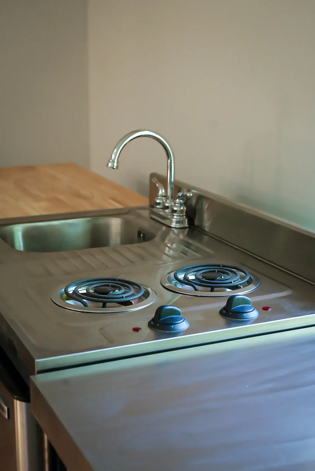 Two-burner cooktop beside the stainless steel sink