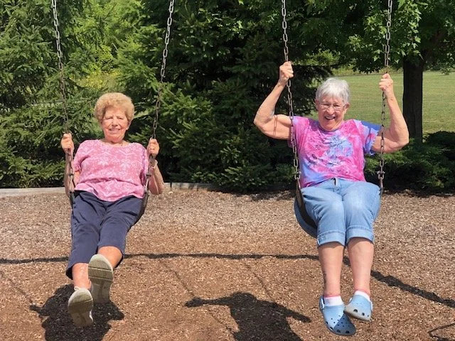 Senior residents enjoying swings at the park