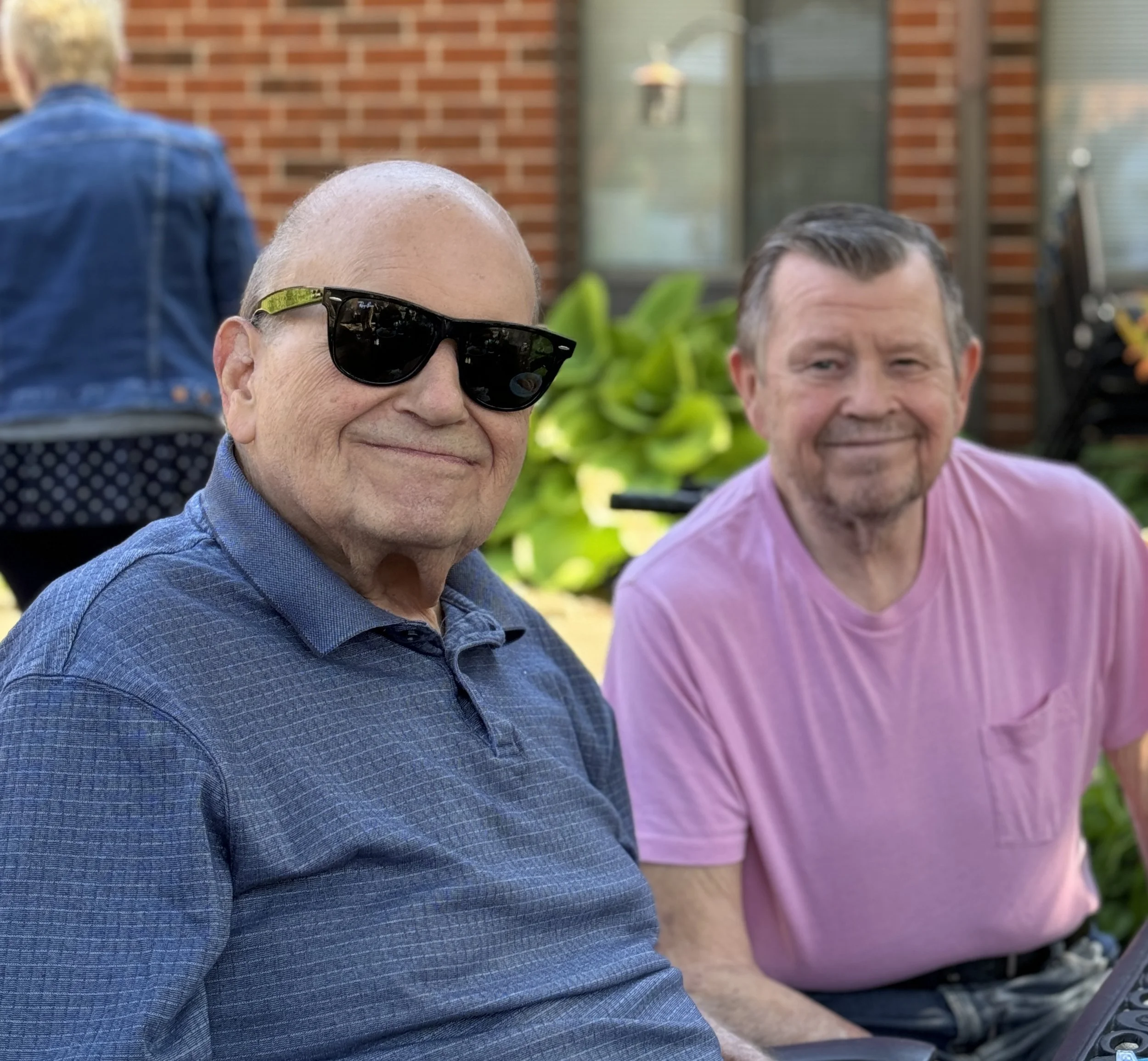 Two male residents smiling together sitting outside