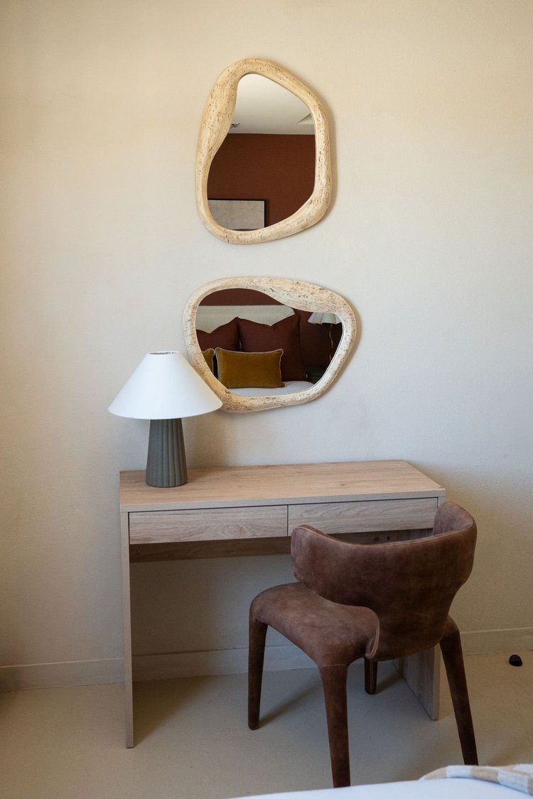 Work desk and velvet chair under wavy mirrors