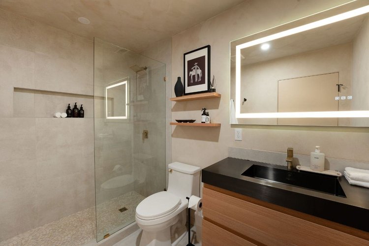 Second bathroom with LED mirror, black vanity and glass walk-in shower