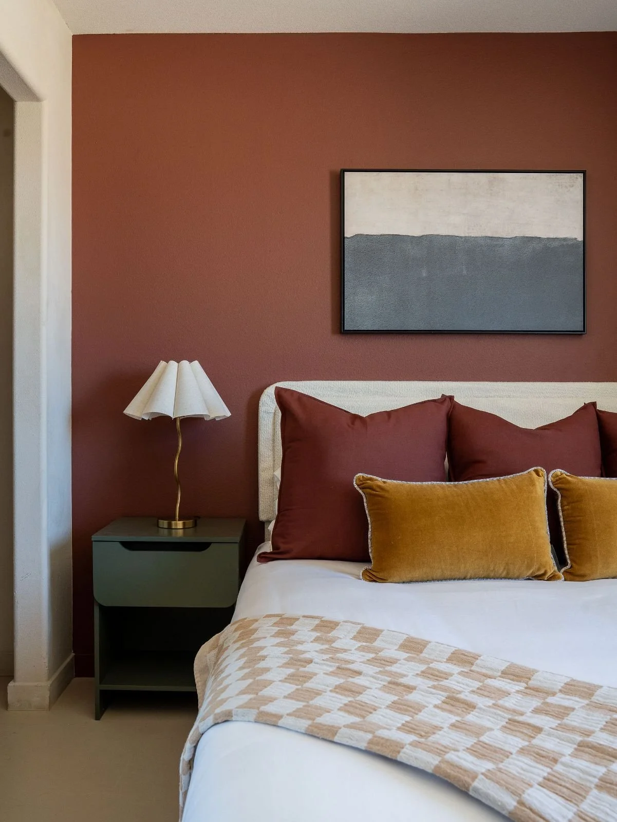 Queen bed against a terracotta accent wall in the Mojave Room at The Desert Willow Joshua Tree