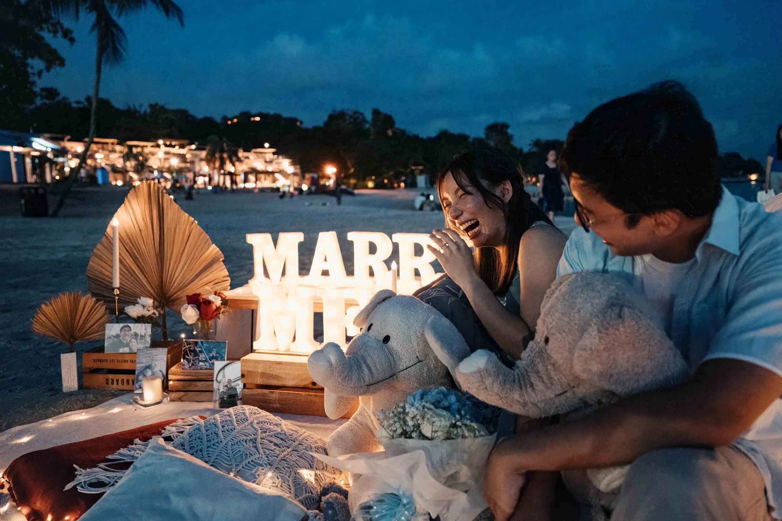 Abraham and Nicole laughing together on Sentosa beach just after their sunset proposal