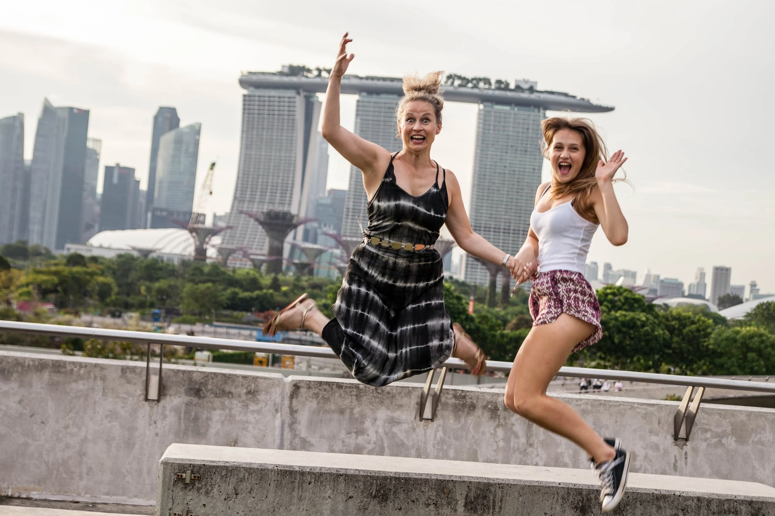 Graduate in gown at Marina Barrage with Marina Bay Sands skyline in the background during a solo photoshoot in Singapore