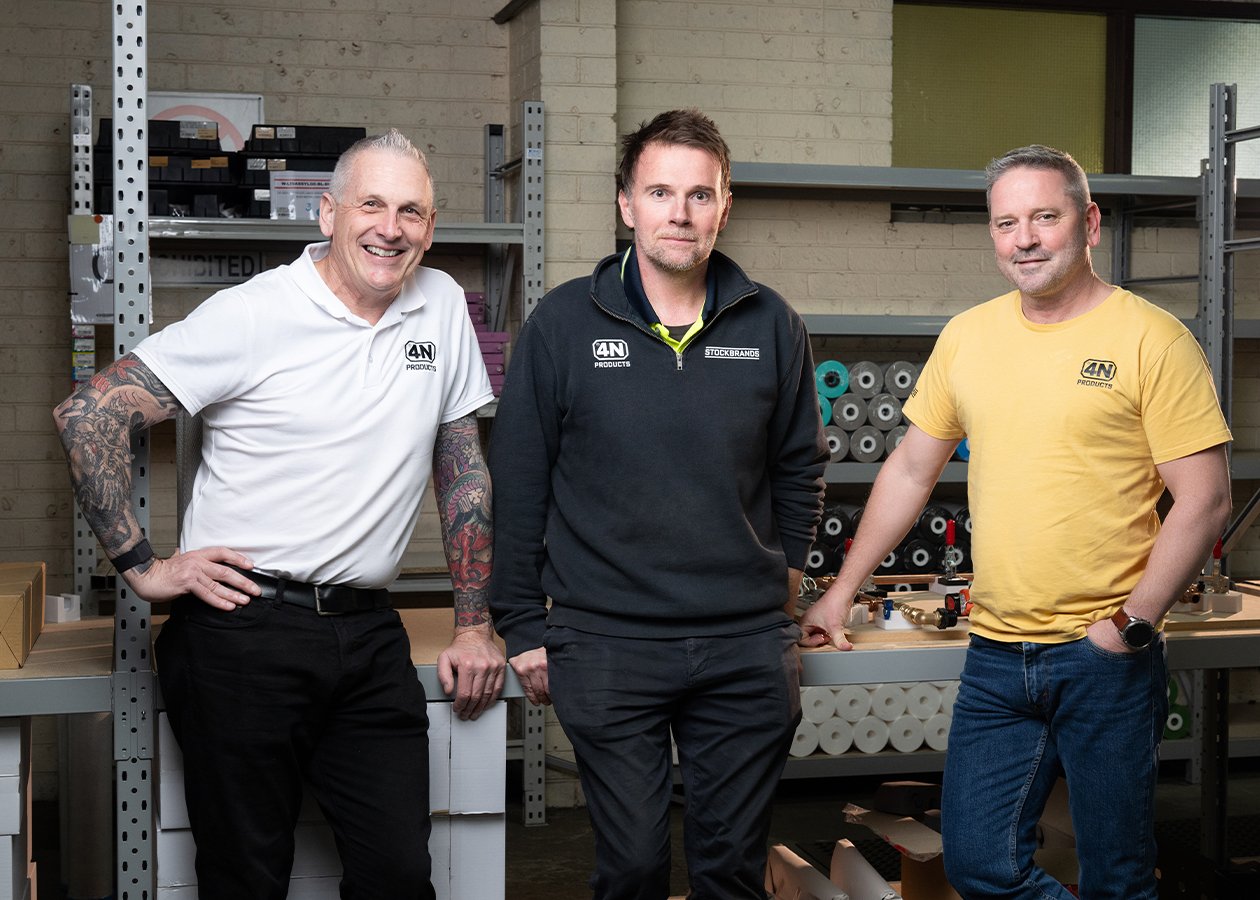 Three 4N employees smiling and standing next to eachother