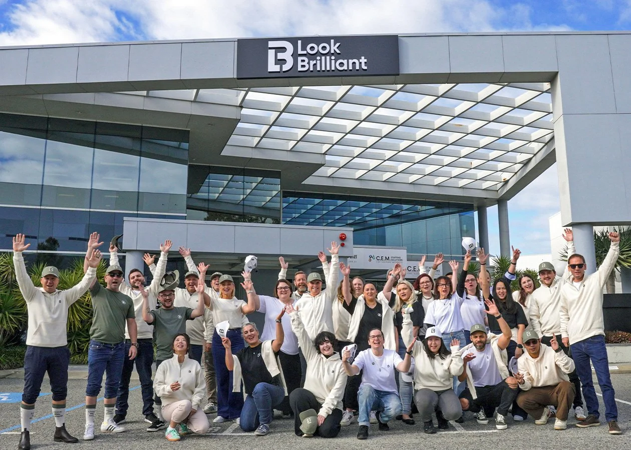 Look Brilliant employees celebrating outside the signage