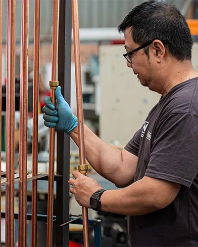 4N employee inspecting copper pipes