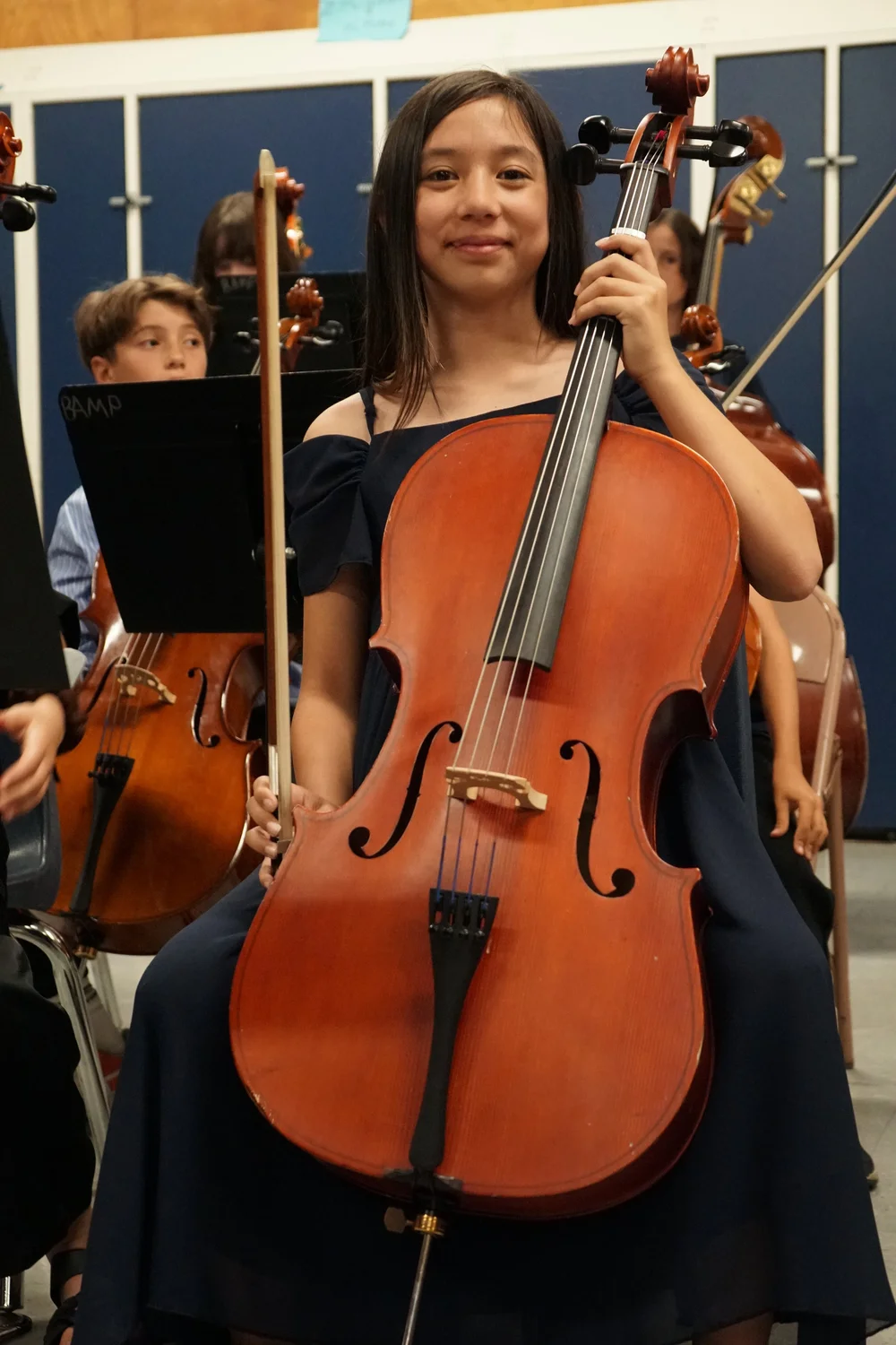 A young cellist with her instrument at a BAMP Cello Academy performance
