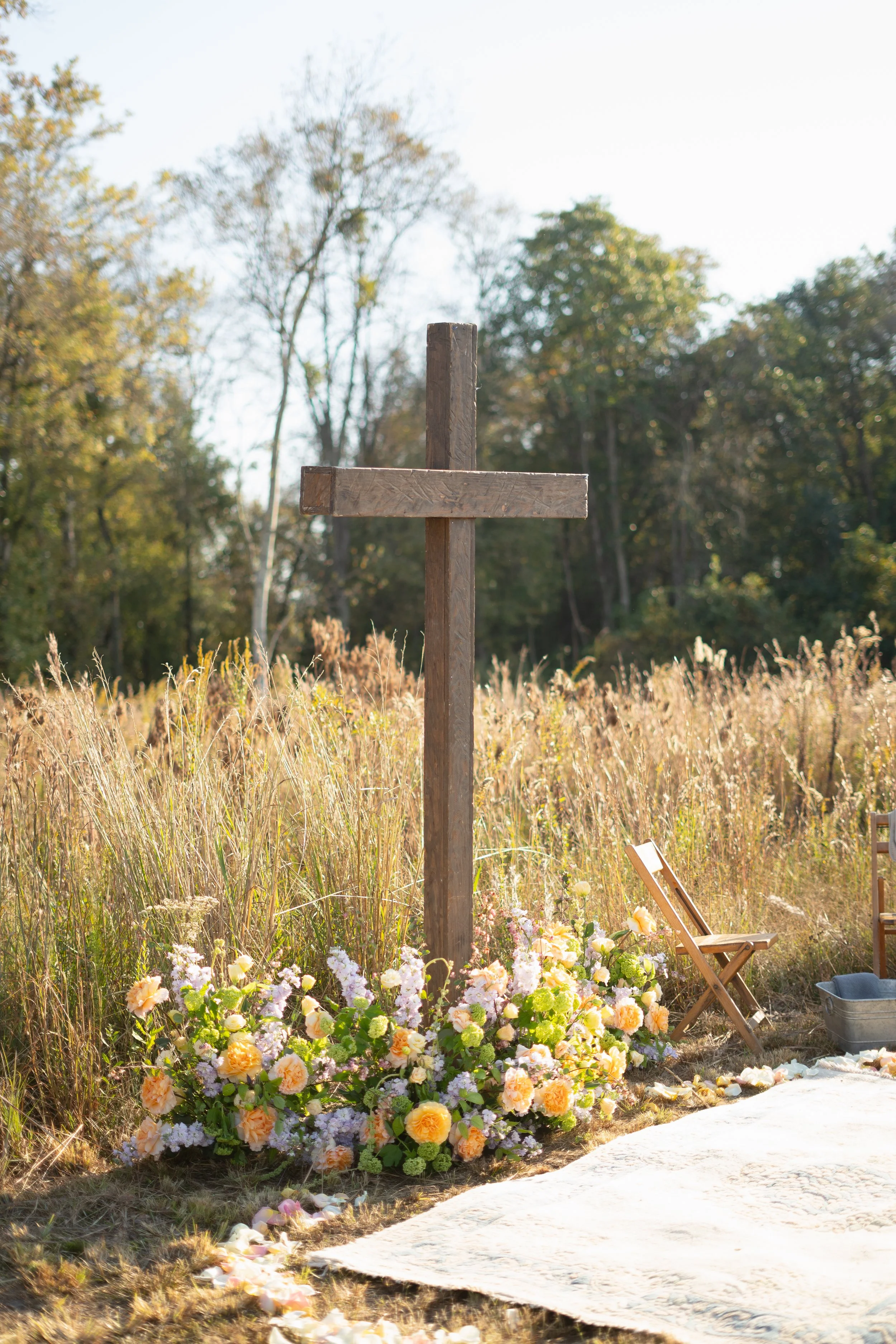 A flower-filled ceremony beside a wooden cross