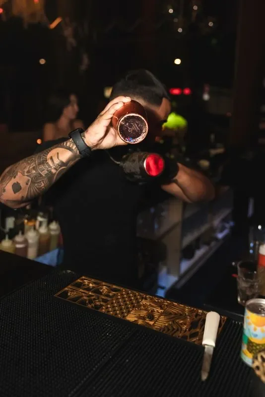 Bartender shaking a cocktail behind the Unico bar