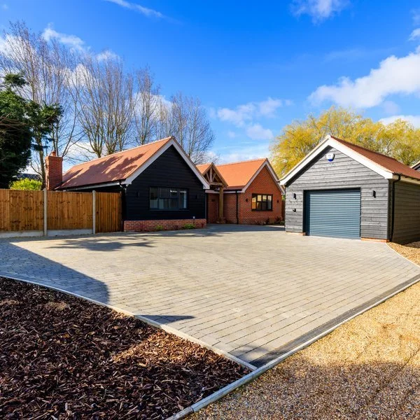 Completed residential project with driveway and outbuildings