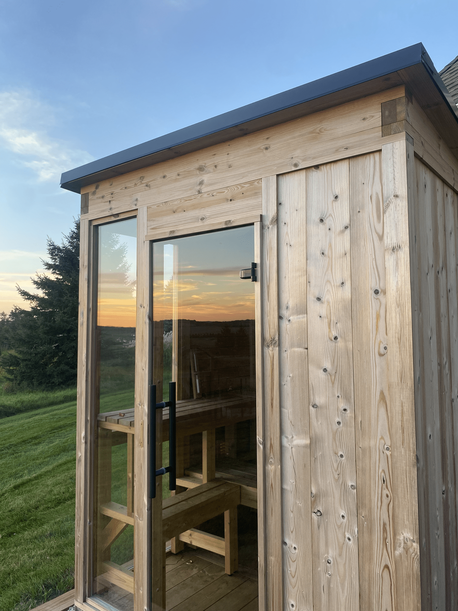 Thermory MOD 4 sauna installed in a Rochester backyard at sunset