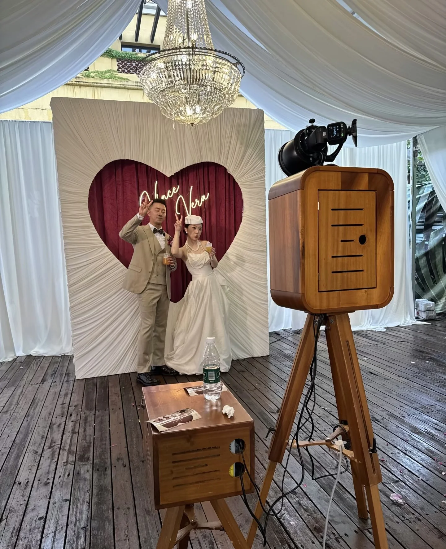 Couple posing at Kairos booth with chandelier backdrop
