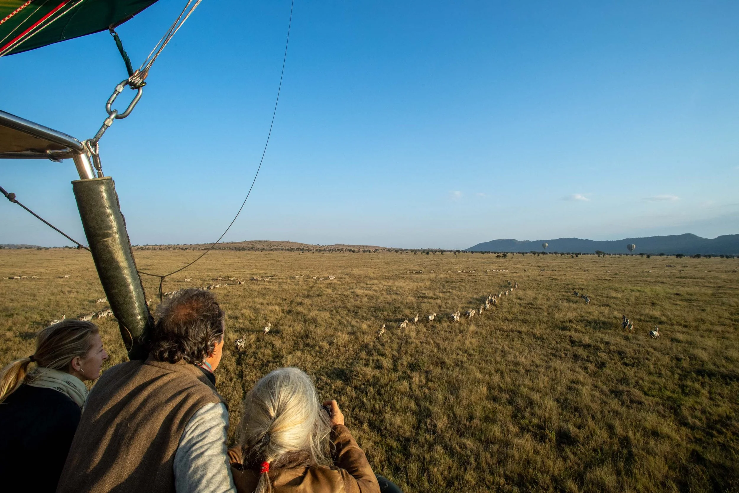 Hot air balloon safari rising over the Serengeti plains at sunrise