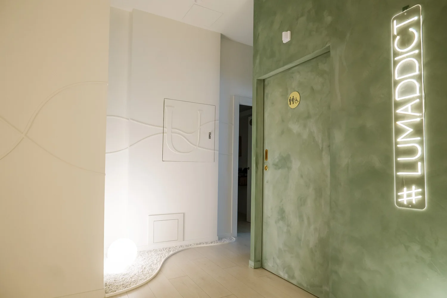 Pasillo del espacio con pared verde y letrero luminoso.